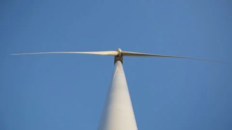 Wind mill with rotating wings on the background of blue sky Stock Footage 141186142