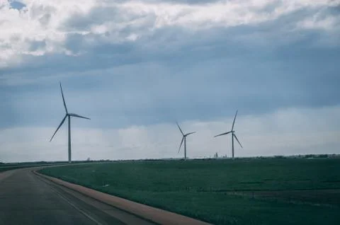 Wind mills by side of empty road Stock Photos