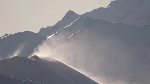 Wind in the mountains. Snow flies down the slopes of snow-covered mountains, Swi Stock-Footage 328283750