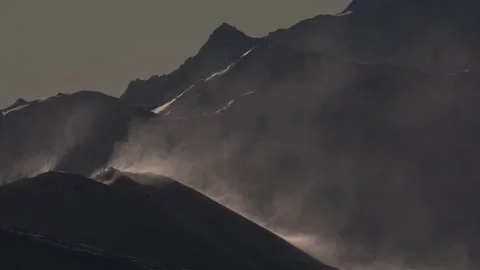 Wind in the mountains. Snow flies down the slopes of snow-covered mountains, Swi Video stock 328283762