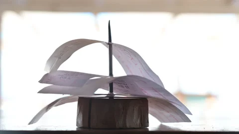 Wind moving checks on receipt holder  Stock Footage 145157860