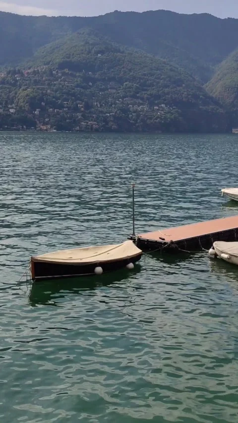 The wind is moving small boats moored in a romantich marina on Lake Como unde Stock Footage 221638514