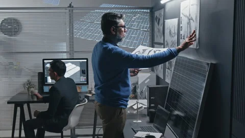 Wind Power Engineer Studying Blueprints with Enhanced Wind Turbine Model Video stock 307964101