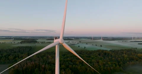 Wind power generating plant early in the morning windmill at sunrise Stock Footage 256864322