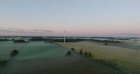 Wind power generating plant early in the morning windmill at sunrise Stock Footage 256864599