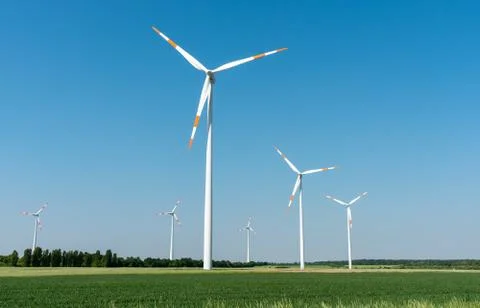 Wind power generators in front of a clear blue sky Stock Photos