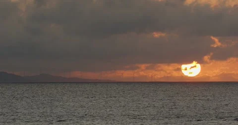 Wind power generators on horizon in ocean, Wind turbines during stunning sunset. Stock Footage 276375201