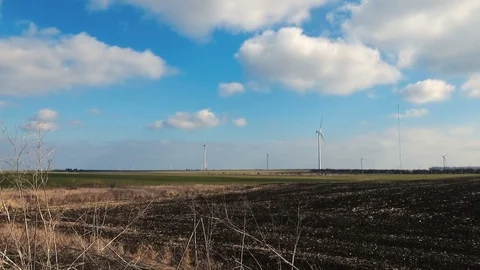 Wind power park green grass blue sky black humus broken ground stock footage Stock Footage 101543134