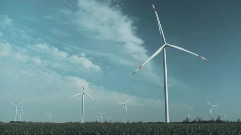 Wind power plant next to winter wheat field against cloudy sky Video stock 157984889