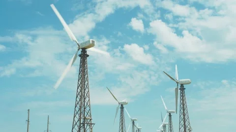 Wind power plant at sunset with slow rotating tower blades generating Stock Footage 156594231