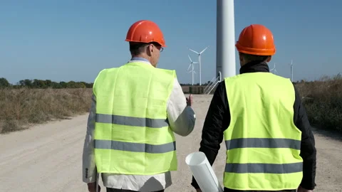 Wind power at rural station workers walk to check turbines Stock Footage 165319984