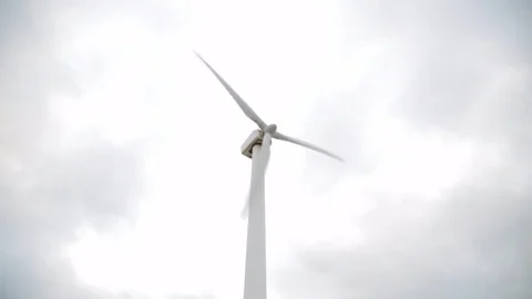 Wind power turbine in cloudy sky producing energy Stock Footage 77030653