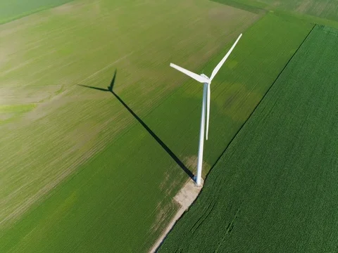 Wind power turbine in a green field, aerial view Stock Footage