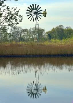 Wind pump by a lake Stock Photos