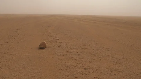 The wind raises the sand in Erg chegaga desert, rock focus, Morocco, Africa 4K Stock Footage 92150366