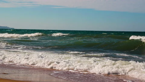 Wind raises white waves on sea. Sea, waves on beach in summertime against blue 스톡 동영상 210481583