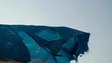 The wind ruffles a torn canvas of blue color. Video stock 132666729