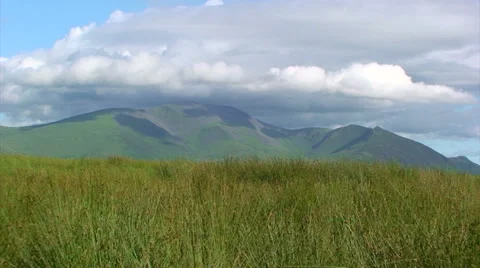 Wind shakes the grass drives clouds over National Park Mountain Stock Footage 39994356