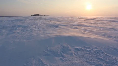 Wind with the snow on the frozen river at sunset in the winter Stock Footage 73659686