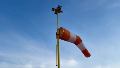 A Wind Sock and Bright Lights Set Against a Clear Blue Sky, Serving Multiple Stock Footage 304830913