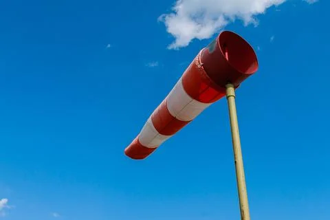 Wind speed meter, red and white stripes on blue background. Windsock indicato Stock Photos