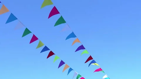 The wind spreads colorful flags against a clear sky. Stock Footage 310366676