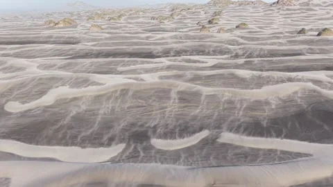Wind Sweeps Sand Across Barren Plain with Grass Tufts, South Island, New Zealand Stock Footage 336177072