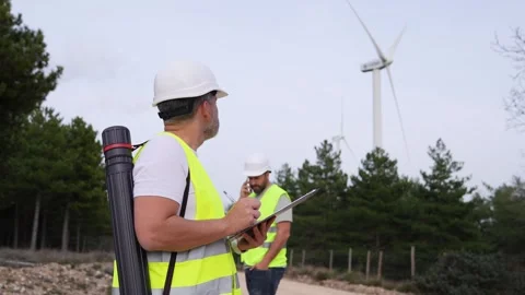 Wind Technicians Communicating with Phone and Clipboard Stock Footage 276312486