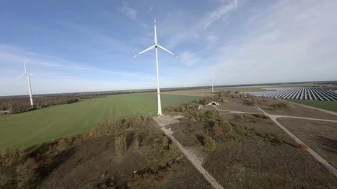 Wind turbine aerial shot with solar panels in 4k Stock Footage