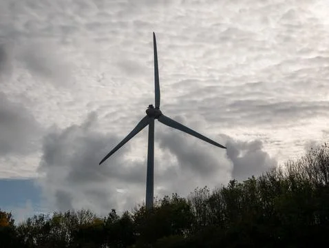 Wind turbine against dramatic cloudy sky Photos