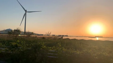 Wind turbine and solar panel farm. Renewable energy farm. Shot during sunset.  Stock Footage 130158520