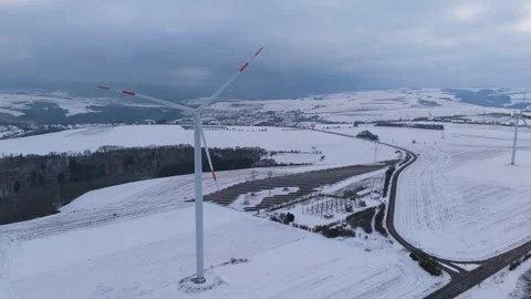 Wind turbine and solar panel in snow, dark doldrums or wind lull in winter Stock Footage 326344295