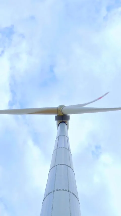 Wind turbine on the background of blue sky in summer with moving clouds Stockbeeldmateriaal 249941513