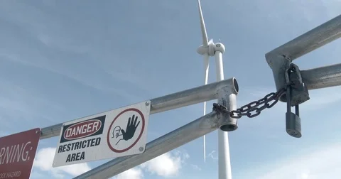 Wind Turbine in Background - Locked Gate in Foreground - 4k Stock Footage