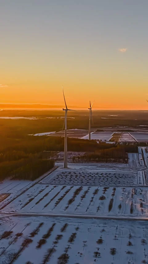 Wind Turbine Beginning to Spin Above Rural Farm Fields at Sunset Stock Footage 337648388