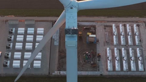 Wind turbine blade rotating over a battery energy storage system plant Stockbeeldmateriaal 331201466