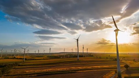 Wind turbine at the edge of a sunlit cloud bank. A white tower rises on the.. Stock Photos