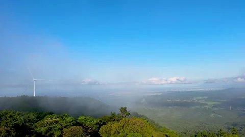 Wind Turbine Emerging Through Mountain Mist Above Green Landscape Stock Footage 339008505