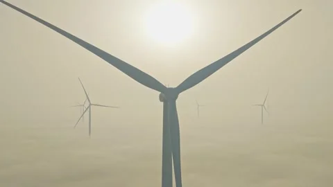 Wind turbine farm generating clean energy above the clouds during foggy sunrise Vídeo Stock 330421253