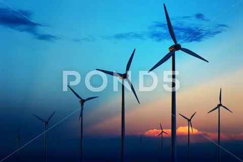 Wind turbine farm at sunset Stock Photos