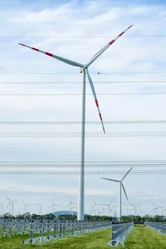 Wind turbine in field under cloudy sky green energy Stock-Fotos