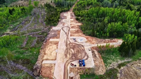 Wind turbine foundation and access road construction site in a green forest Stock Footage 337791744