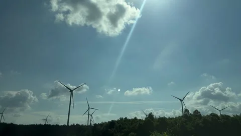 Wind turbine generating clean electricity, towering above natural green forest, Stock Footage 337191272