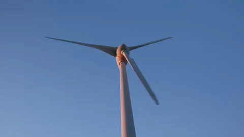 Wind turbine generating clean energy under clear blue sky. Stock Footage 329940966