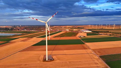 Wind turbine generating clean energy over rural golden fields. Aerial view of a Stock Footage 339016551