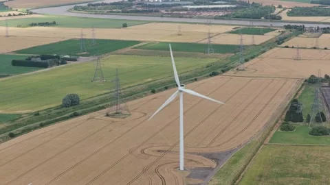 Wind Turbine Generating Power Above Expansive Rural Fields and Power Lines Stock Footage 340292700