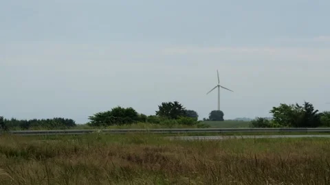 Wind turbine generating renewable energy in rural field Vídeo Stock 338073073