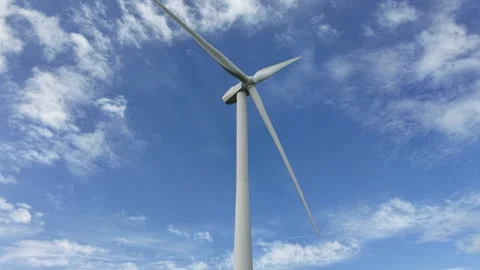 Wind turbine generating renewable energy against blue sky Stock Footage 345233579