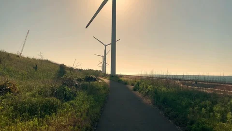 Wind turbine generator under the sun by the sea on a sunny day. Video going away Stock Footage 130158490