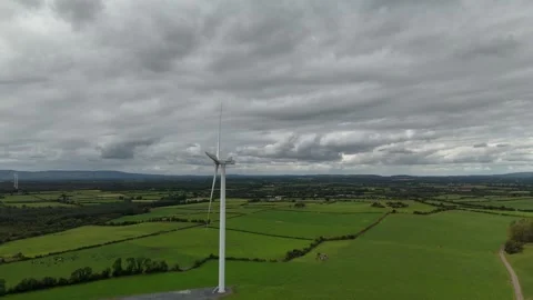 Wind Turbine in Green Fields Under Cloudy Sky Aerial View Stockbeeldmateriaal 333412920